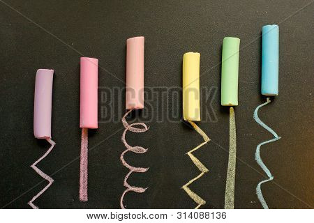 Crayons Of Different Colors Lie On The Slate Ieave A Trace