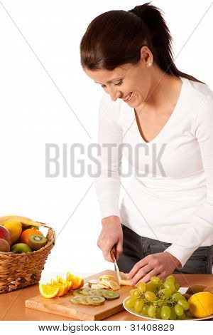 Attractive Young Woman Cuting Fruits And Preparing Fruit Salad