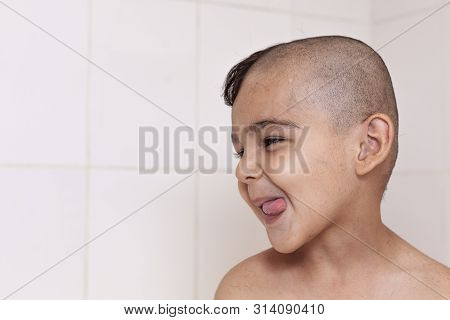 Six-year Boy At Haircutting At Home. Father Cut Half Of The Son's Hair Off At The Bathroom