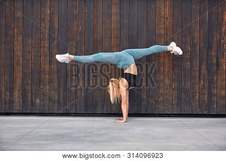 Beautiful Athletic Young Girl Gymnast In Sportswear, Working Out, Element Of Gymnastics, Doing The S