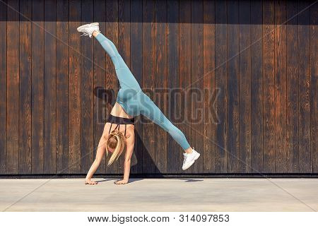 Beautiful Athletic Young Girl Gymnast In Sportswear, Working Out, Element Of Gymnastics, Doing The S