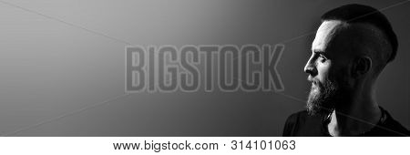 banner with free copy space for text. portrait. Profile of a young man with a red beard on a gray ba