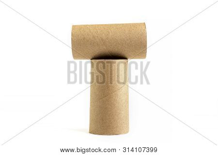 Letter T From Composition Of Two Cardboard Paper Tubes On White Background. Close-up Of Empty Toilet