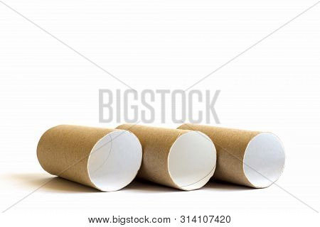 Three Cardboard Paper Tubes In The Row On White Background. Close-up Of Empty Toilet Rolls, Copy Spa