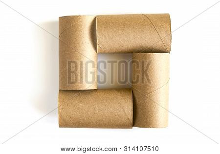 Square Formed From Of Four Cardboard Paper Tubes On White Background. Close-up Of Empty Toilet Rolls
