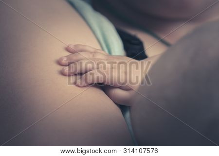 Close Up Of Baby Hand While Breastfeeding.  Mother Breastfeed Baby. New Born Baby Breastfeeding. Mot