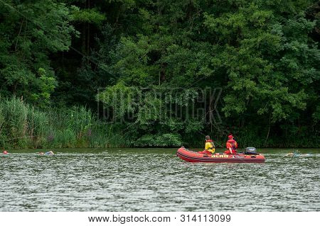Degenbachsee, Germany, 28. July 2019. Water Rescuer On A Motorboat Watching Swimming People During I