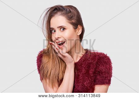 Portrait Of Amazed Beautiful Young Woman Looking At The Camera With Surprised Expression. Pretty Con