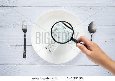 Hand Use The Magnifying Glass To Zoom In To See The Details Of The Nutrition Facts Label On The Side