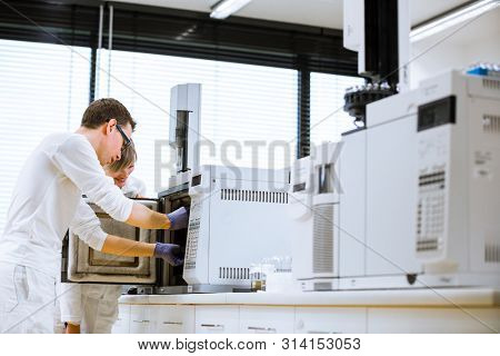 senior male researcher carrying out scientific research in a lab using a gas chromatograph (shallow DOF; color toned image)