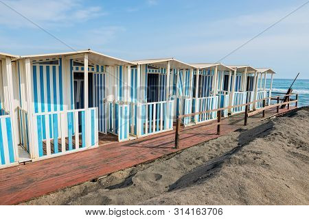 Beautiful Sea, The Black Sandy Beach And White And Blue Striped Beach Houses, Tyrrhenian Sea Near Ro