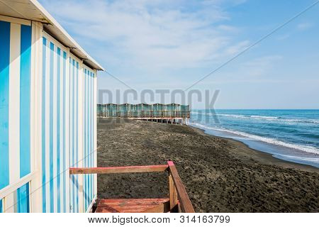 Beautiful Sea, The Black Sandy Beach And White And Blue Striped Beach Houses, Tyrrhenian Sea Near Ro