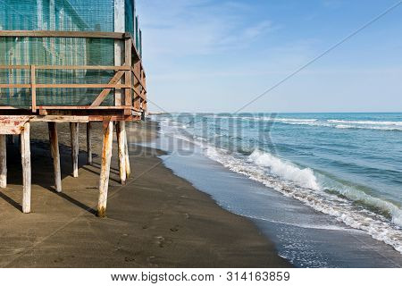 Beautiful Sea, The Black Sandy Beach And White And Blue Striped Beach Houses, Tyrrhenian Sea Near Ro