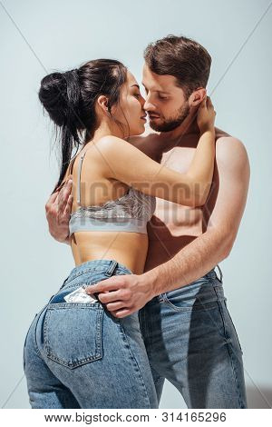 Sexy Couple Hugging And Trying To Kiss While Man Putting Off Condom From Jeans Of Girl