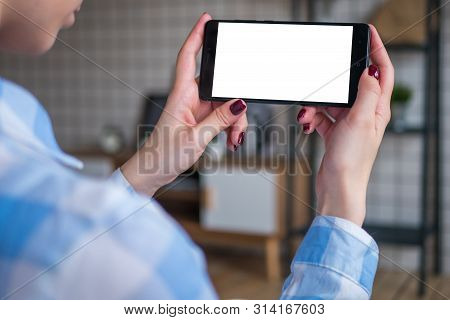 Mockup Image: Woman Looking At Black Smartphone With White Blank Screen. Close Up View Of Woman Hand