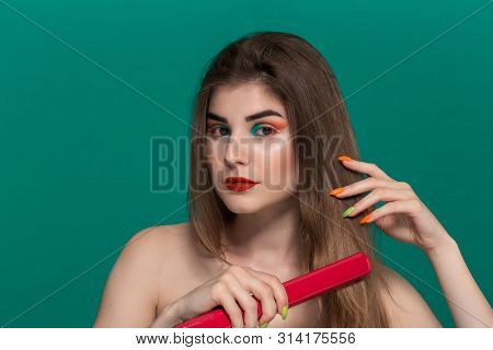 Portrait Of Beautiful Young Woman With Bright Color Make-up Doing Hair Style Herself With A Purple S