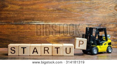 Forklift Truck Carries A Letter Block P To Inscription Startup. The Concept Of Raising Funds For A S