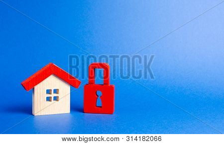House Figurine And A Red Padlock. Security And Safety. Confiscation For Debts. Alarm System. Seizure