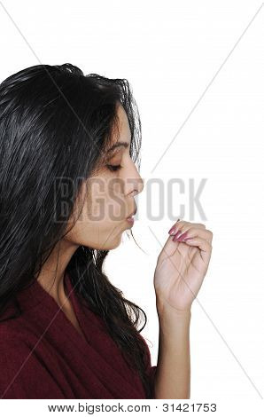 一位女士吹她被绘的指甲去干。