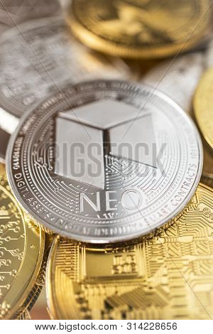 Neo Physical Coin On The Stack Of Other Different Cryptocurrencies. Close-up Photo Of Neo With Shall