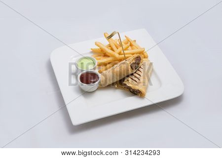 A Low Contrast Hero Shot Of A Beef Wrap Sandwich With Samurai & Alger Sauce And Fries On The Side, O