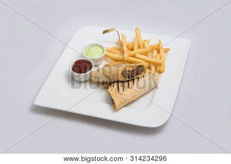 A Low Contrast Hero Shot Of A Beef Wrap Sandwich With Samurai & Alger Sauce And Fries On The Side, O