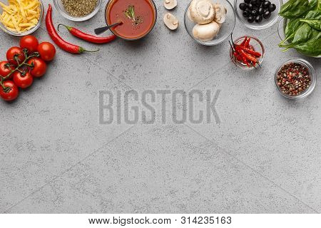 Ingredients For Cooking Pizza. Sauce, Tomatoes And Herbs On Grey Table With Copy Space