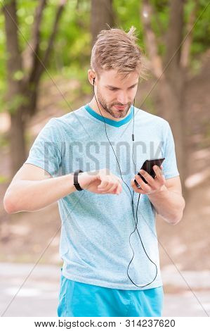 Monitoring And Boosting His Training. Sportsman Tracking His Training With Fitbit And Smartphone. Fi