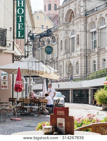 Baden-baden, Germany - Jul 7, 2019: Outdoor Terrace With Customers People At The Hotel With Bader Ta