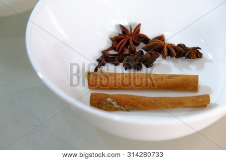 Cinnamon And Star Anise Placed In A White Bowl.