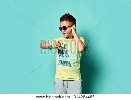 Portrait Of A Cool Young Guy Talking On A Mobile Phone In The Style Of Summer Clothes In Sunglasses 