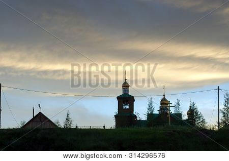 A Wooden Church With Golden Domes Stands At Sunset Under The Fat Sky On A Hill In The Northern Villa