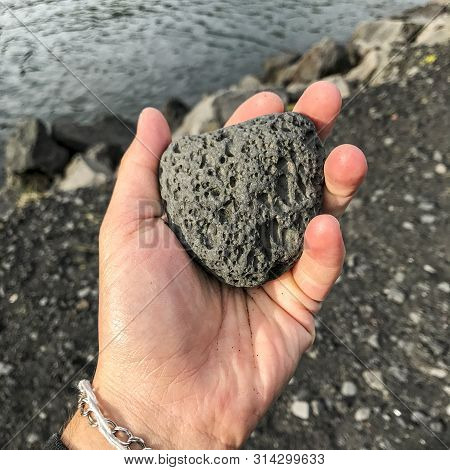 Person Holding Chunk Of Volcanic Rock In Iceland