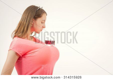 Young Woman With Wineglass On Big Fake Breasts On White Background, Copy Space