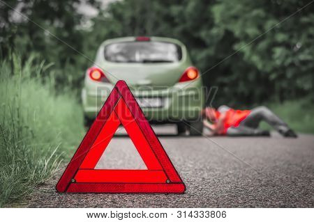 Red Warning Triangle And Broken Car On Road - Car Breakdown Concept