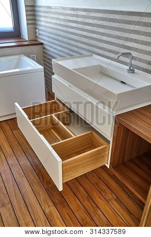 Wall mounted bathroom vanity in luxury bathroom with striped tiles. Stylish interior of modern bathroom. Details furniture