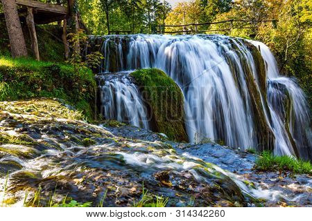 The small Croatian town of Slunj. Magnificent cascade of waterfalls on the Koran River. Magnificent forests surround the city and the river. The concept of ecological, active and photo tourism