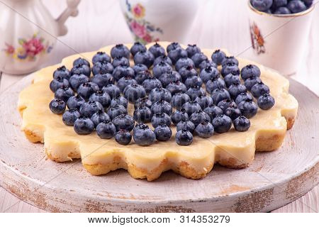 Homemade Cheesecake Decorated With Blueberry Over On White Wooden Background. Top View
