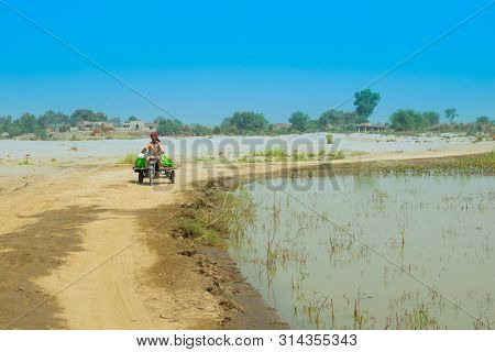 Punjab,pakistan-june 23,2019:an Unidentified Man Driving A Moto Rickshaw In A Flood Affected Area,bl