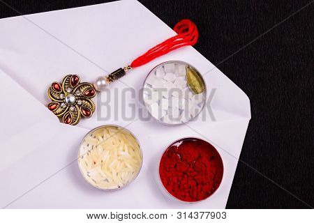 Indian Festival - Elegant Rakhi With Rice Grains, Kumkum, Sugar Rock And Cardamom In A Flat Tin Box 