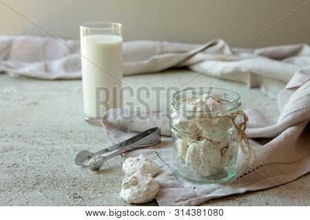 Traditional Beze Or Meringues With Nuts In A Glass Jar On Concrete Background. Copy Space. A Glass O