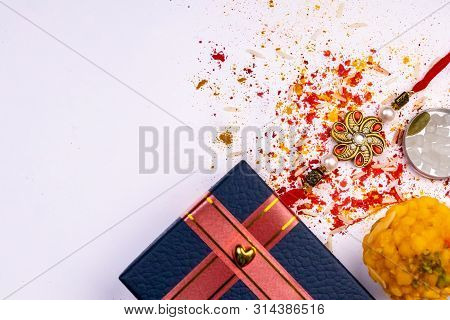 Scattered Rice Grains, Kumkum, Haldi, Sweets With Cardamom, Rock Crystal Sugar And Blue Gift Box On 