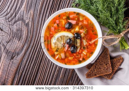 Traditional Russian Meat Soup Solyanka In Bowl On Rustic Wooden Table