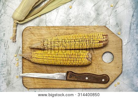 Shucked And Cleaned Sweet Corns On Cutting Board. Sweet Corns On Desk.