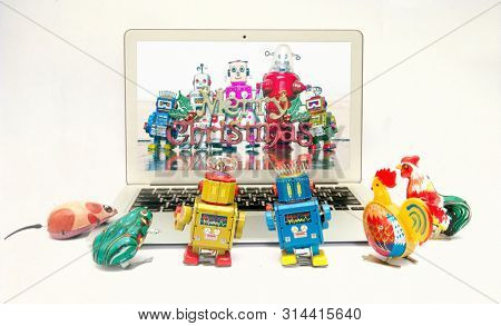 retro tin toys looking at a there friends celerbrating Christmas on a laptop computer 