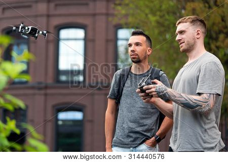 Young Handsome Men Launching Drone Quadcopter At Urban Background.