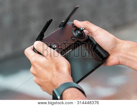 Close Up Of Man With Drone Quadcopter Joystick Controller At Urban Background.