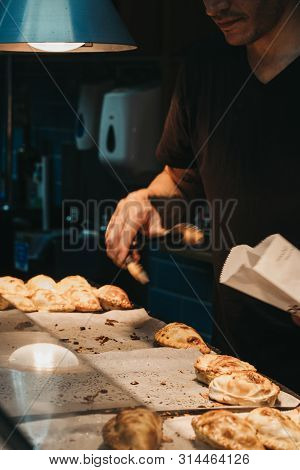 London, Uk - July 23, 2019: Man Selling Empanadas At Porteno Market Stall Inside Borough Market, One