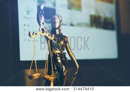 Statue Of Justice And Computer On Desk