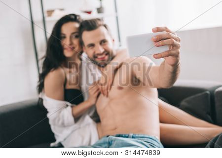 Handsome Man And Sexy Woman In Shirt And Bra Smiling And Taking Selfie